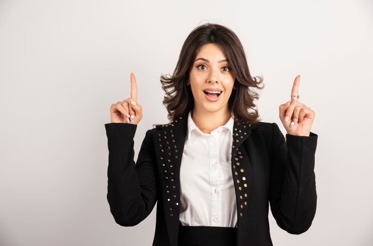 Girl standing with fingers pointing up.