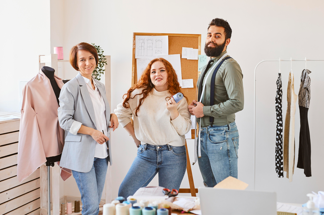 Three people from fashion community are standing.